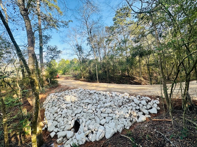 Fresh rip rap stone staged for a culvert end treatment
