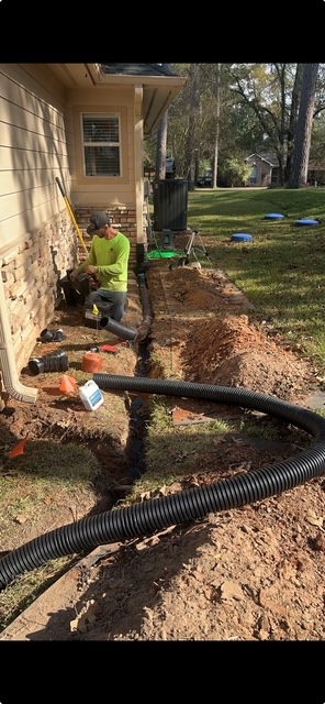 Corrugated downspout drain line installed along a house foundation